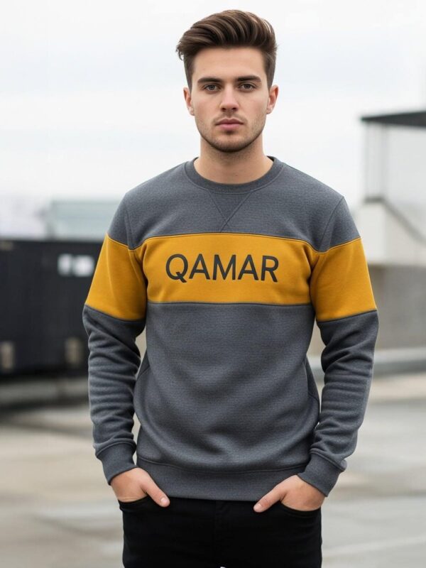 Jonge man draagt een sweatshirt van QAMAR EXPORTS op een dak.