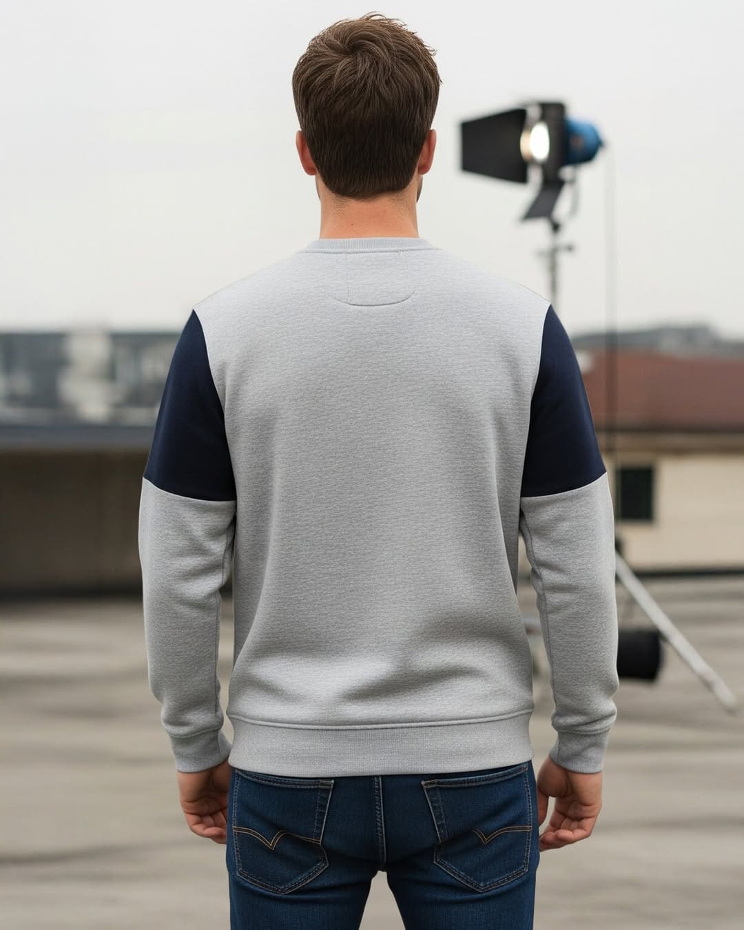Man staat op dak met professionele lichtopstelling voor fotoshoot of filmen.